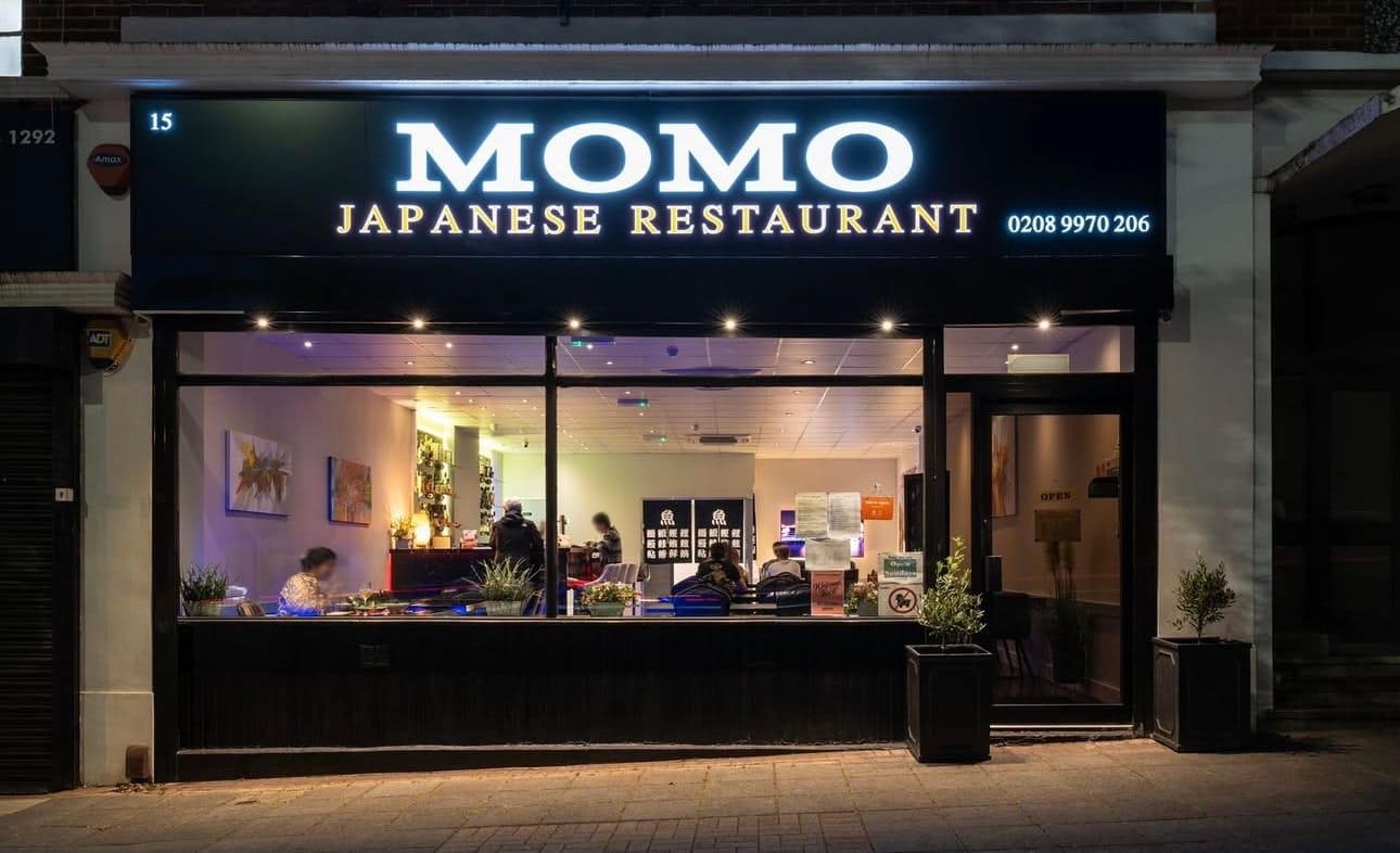 Momo Japanese Restaurant’s shopfront at 15 Ashbourne Parade, lit up at night